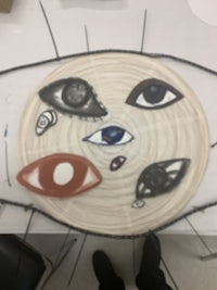 a student is making a paper plate with eyes on it