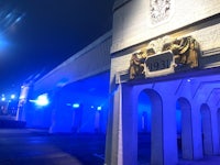 the entrance to a building is lit up with blue lights